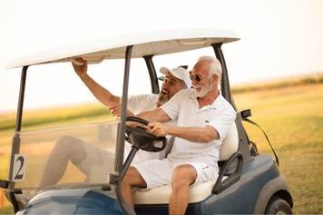 A photo of a female audiologist providing a hearing aid consultation to a middle-aged male client with brown skin and a beard.